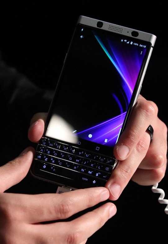 27일(현지시간) 세계 최대 모바일 전시회 '모바일 월드 콩그레스(MWC) 2017'이 열린 스페인 바르셀로나 피라 그란비아 내 블랙베리 부스에서 행사도우미가 블랙베리 키원을 들어보이고 있다.         쿼티 키보드를 그대로 유지해 마니아 층을 유지하고, 다양한 단축키를 적용하는 등 새로운 소비자 층을 잡기 위한 노력을 아끼지 않았다. 가격은 프리미엄폰과 중저가폰의 중간 수준인 549달러(약 62만 원)로 책정됐다.